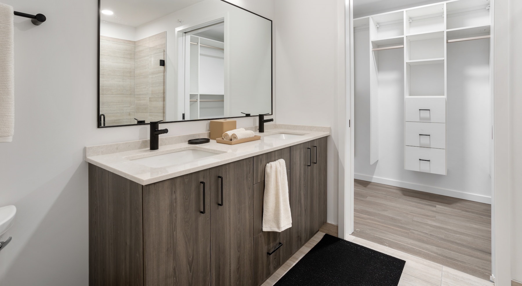 bathroom with large closet and two sinks